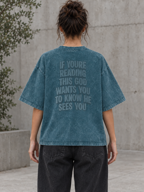 Model wearing the GOD SEES YOU Heavy Wash Tee from behind, showing the tonal back graphic and full-length fit.