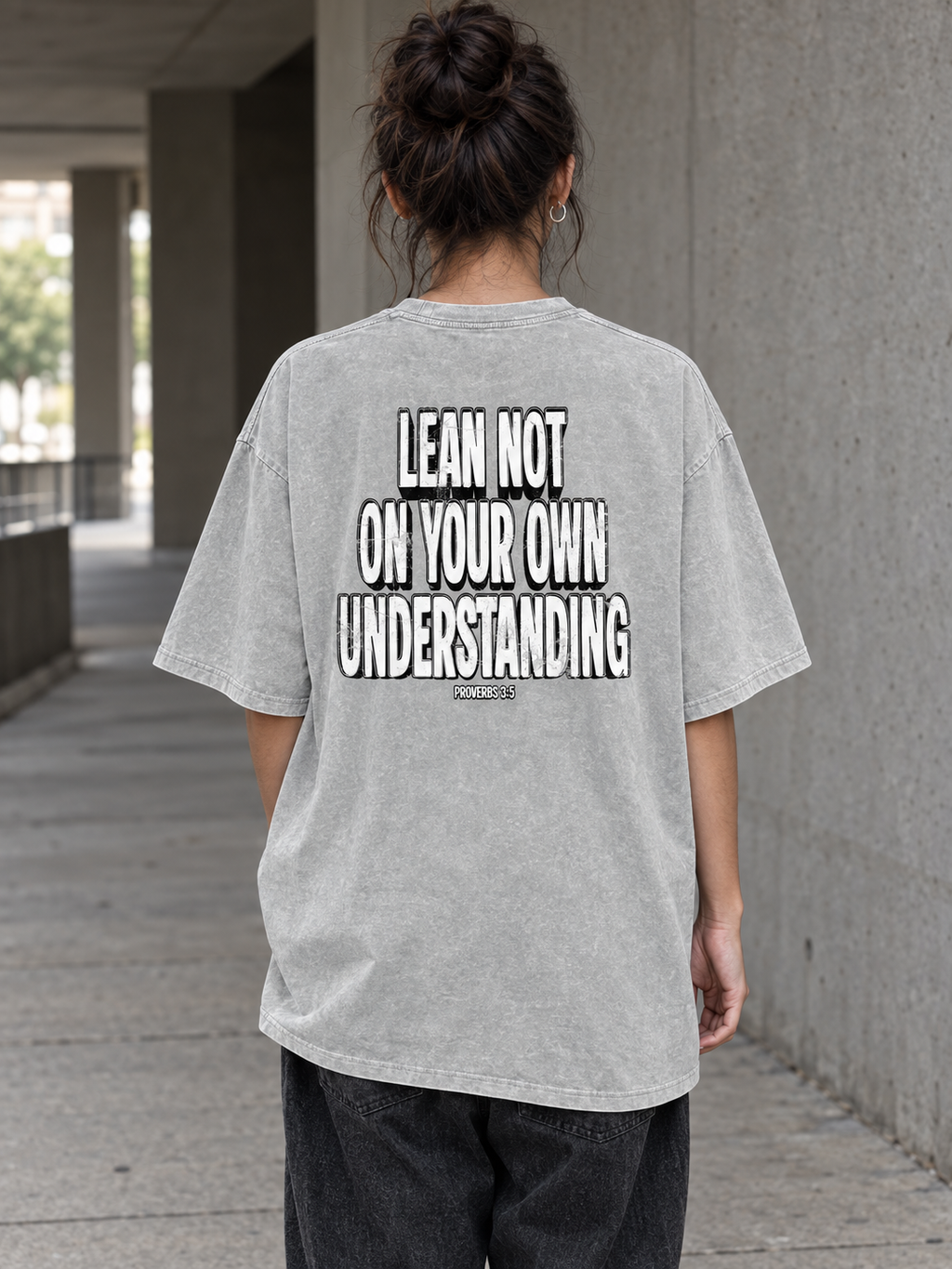Model wearing LEAN NOT ON YOU Snow Washed Tee from behind, showing the Proverbs 3:5 statement graphic.