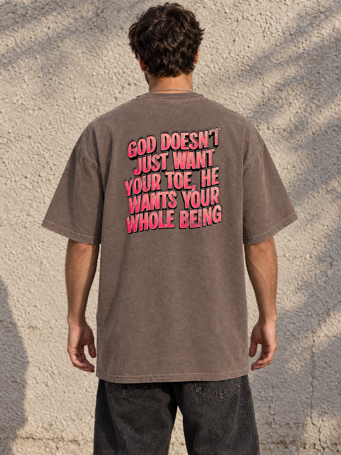 Model wearing GOD DOESN'T WANT YOUR TOE Vintage Wash Tee from behind, showing the pink statement graphic and normal tee length.